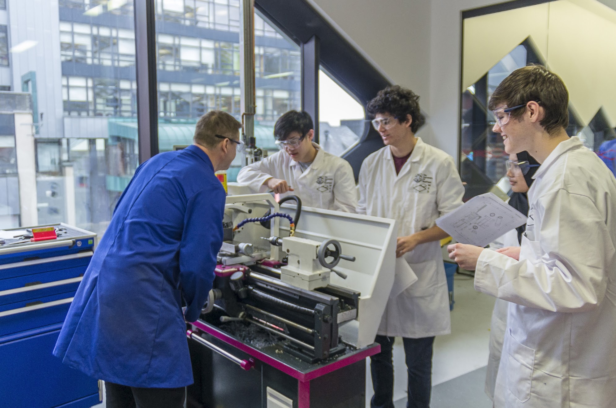 A technician shows students how to operate a drill