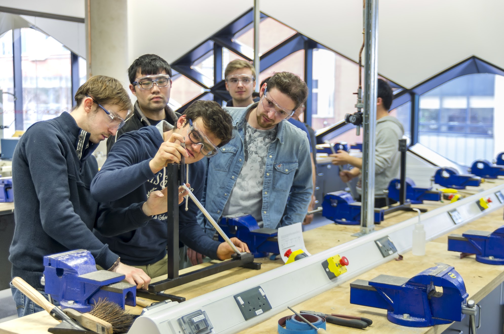 Students measure a sample in a vice