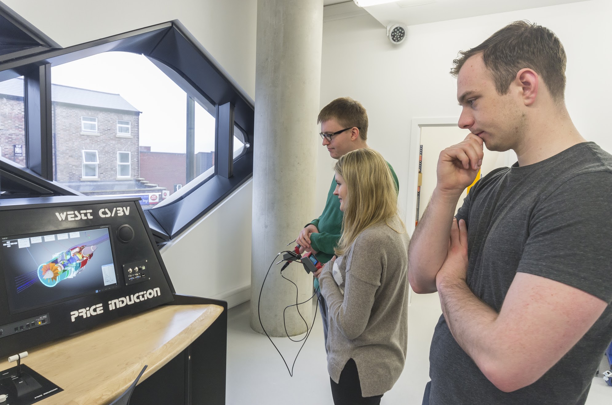 Students look at an engine simulation on a computer screen